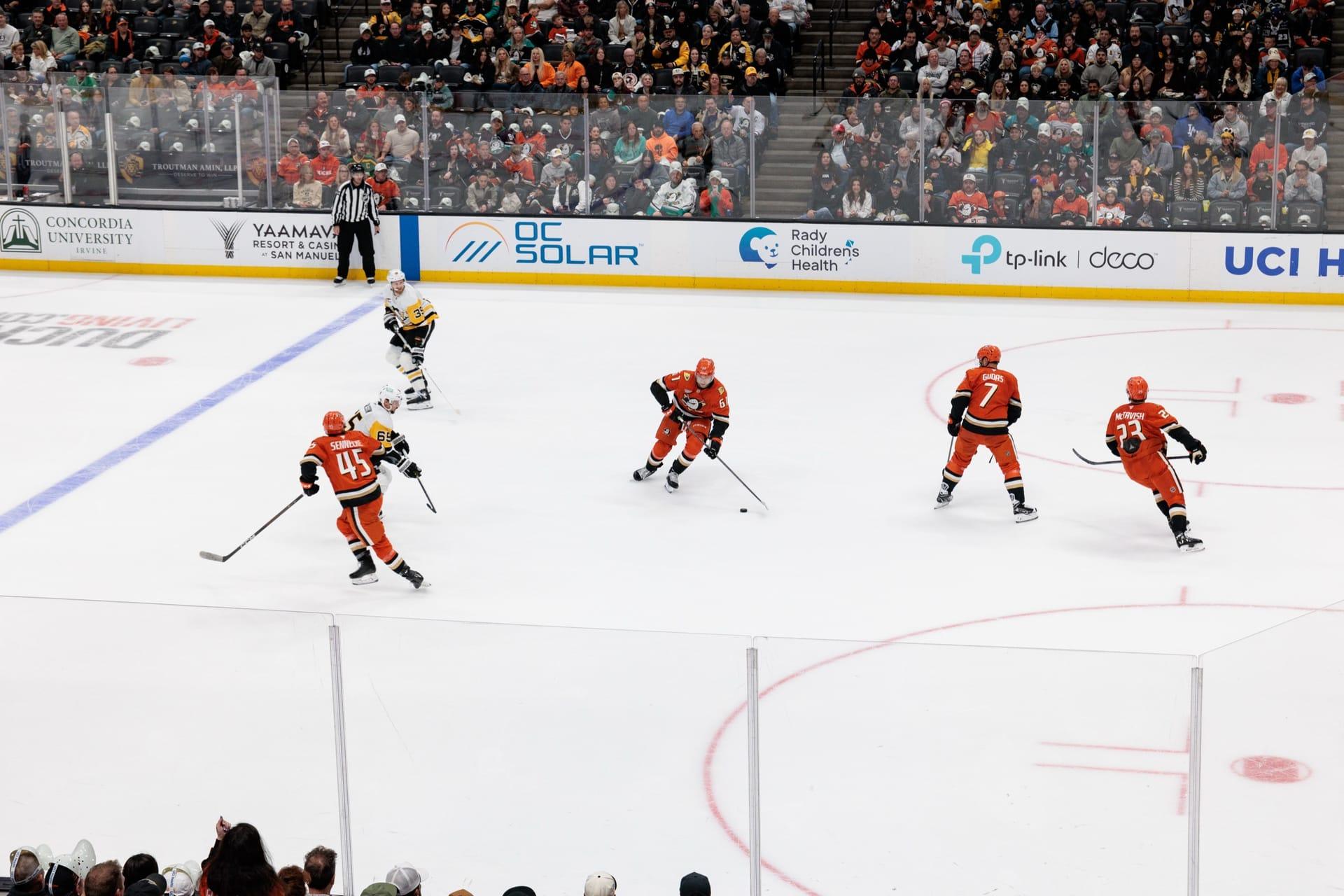 The OC Solar logo on the Honda Center dasher boards behind live Anaheim Ducks game action